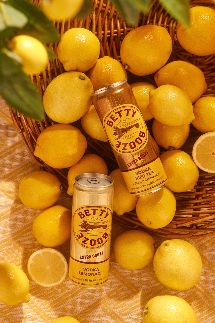 Betty Booze Extra Boozy cans on top of lemons